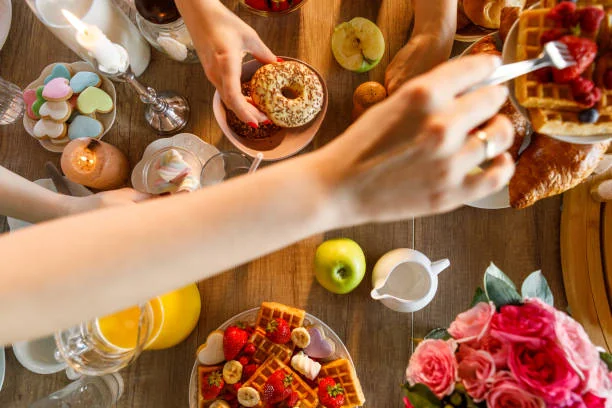 table de brunch garnie de gaufres fruits frais jus doreange et viennoiseries partagee entre amies a lille