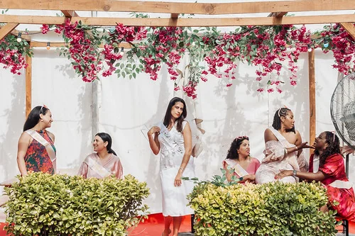 groupe de femmes en tenue elegante celebrant un evjf a paris sous une pergola fleurie