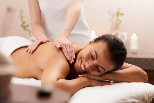 Femme souriante recevant un massage relaxant pendant un massage , dans une ambiance bien-être et cocooning.