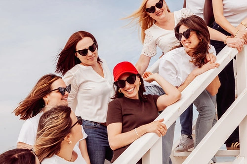 groupe de femmes souriantes lors d un evjf prenant la pose sur un escalier en exterieur meilleurs gages et defis evjf