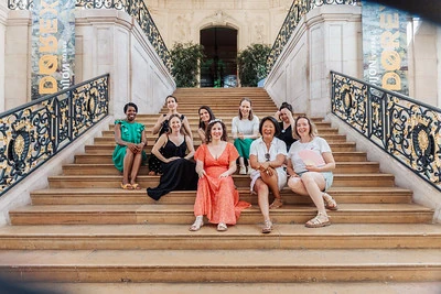 Groupe de femmes posant sur les escaliers d’un bâtiment 