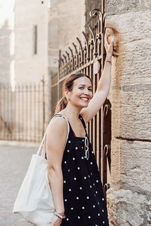 Que visiter à Dijon pendant un EVJF, femme souriante touchant la célèbre chouette de Notre-Dame pour porter bonheur.
