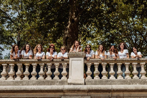 Que visiter à Dijon pendant un EVJF, groupe de femmes souriantes posant sur une balustrade en pierre dans un parc verdoyant et ensoleillé.