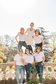 Que visiter à Dijon pendant un EVJF, groupe de femmes souriantes en tenue blanche posant ensemble sur une terrasse dans un parc ensoleillé.