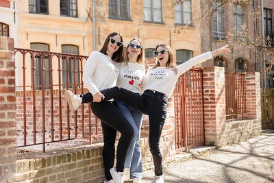 future mariee et ses deux amies posent en souriant  dans une rue ensoleillee