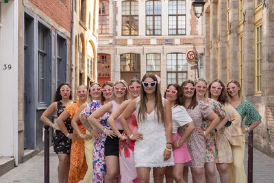 groupe de femmes pose dans une rue du vieux lille pendant un evjf avec la mariee au centre