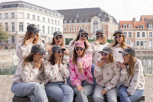 groupe de copines lors d un evjf a lille posant ensemble devant les bâtiments et le canal du vieux lille