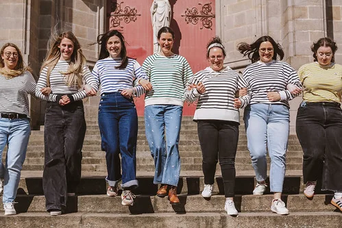 groupe de femmes marchant main dans la main sur les marches de l’eglise saint nicolas 