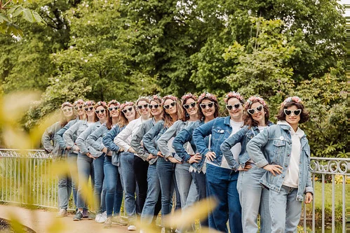 groupe de femmes en tenue jean et lunettes coeur posant au jardin des plantes de nantes pendant un evjf