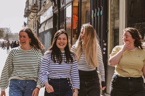 groupe de femmes marchant et riant dans une rue commerçante de nantes pendant un evjf
