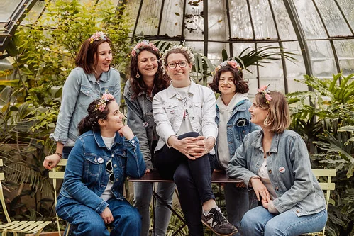 groupe de femmes souriantes assises dans une serre du jardin des plantes de nantes pendant un evjf
