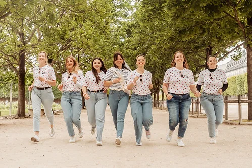 Groupe de femmes souriantes courant ensemble dans le jardin des Tuileries 