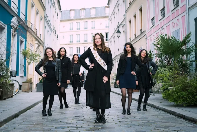 Groupe de femmes élégantes posant dans une rue colorée de Paris pendant un EVJF, ambiance chic et complice.