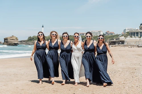 groupe de femmes marchant sur la plage lors d’un shooting photo evjf à biarritz sous un ciel ensoleillé