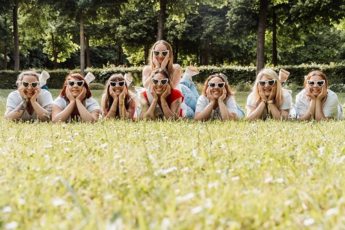 groupe de femmes allongées dans l’herbe portant des lunettes blanches en forme de cœur lors d’un shooting photo evjf à caen