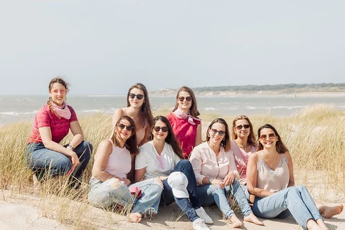 groupe de femmes assises dans les dunes du touquet paris plage souriant lors d’un shooting photo evjf face à la mer